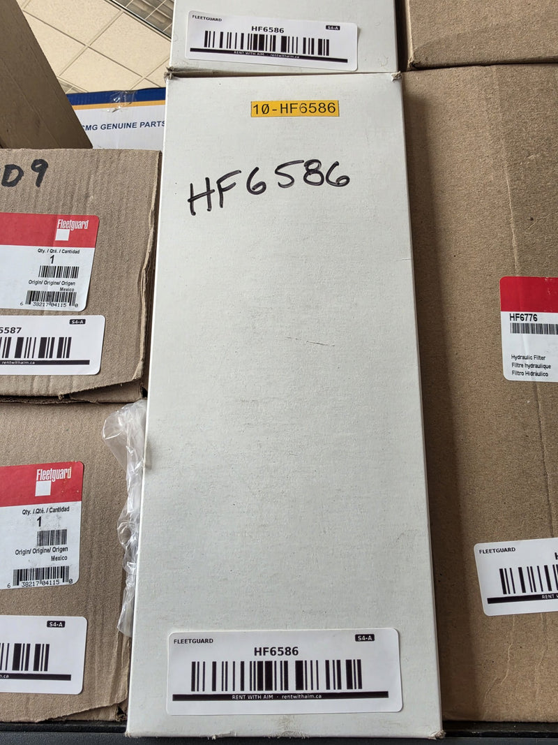 Fleetguard HF6586 hydraulic filter in a plain white carton hand marked HF6586, AIM Fleetguard barcode labels top and front, yellow shelf tag reading 10 HF6586