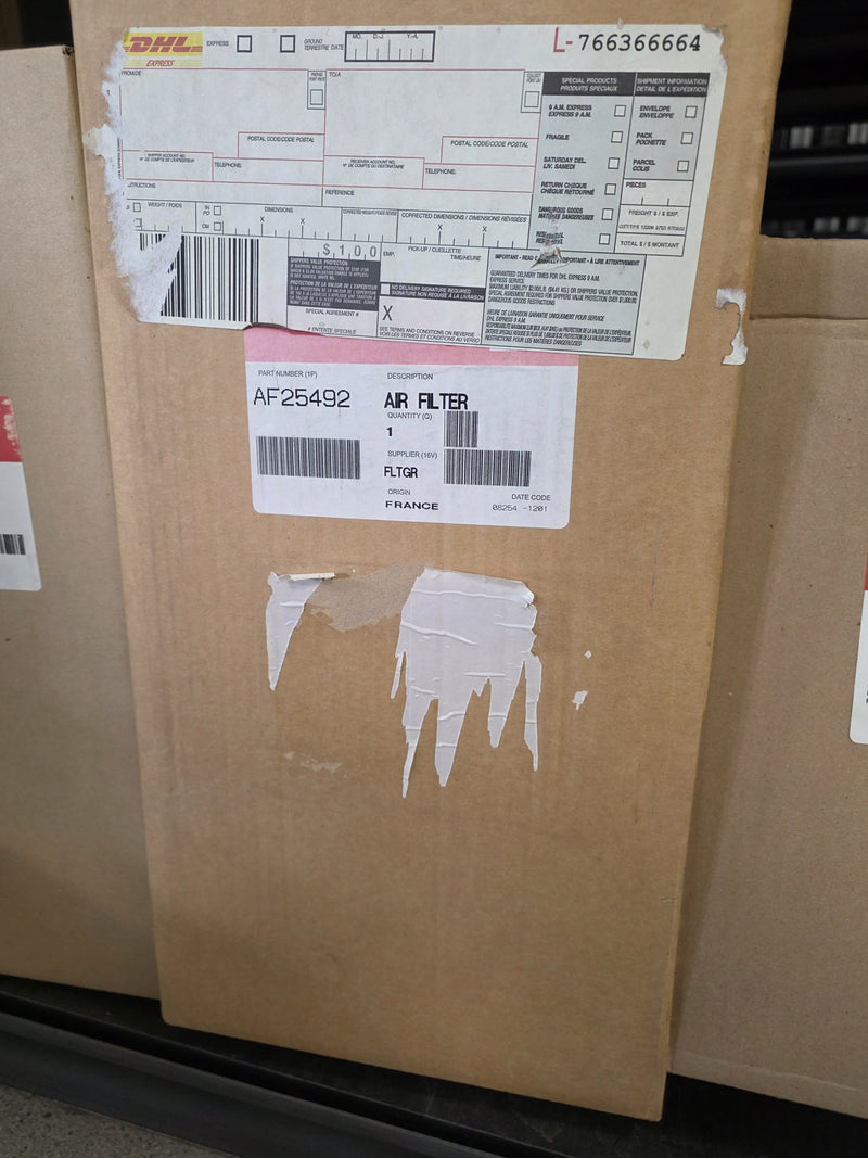 Genuine Fleetguard AF25492 air filter in a sealed carton with a DHL Express airbill still taped to the box, origin France, photographed in Prince George BC
